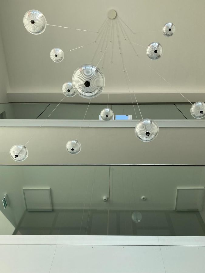 Deckenleuchte aus mehreren Glaskugeln über einer Glasbrüstung
