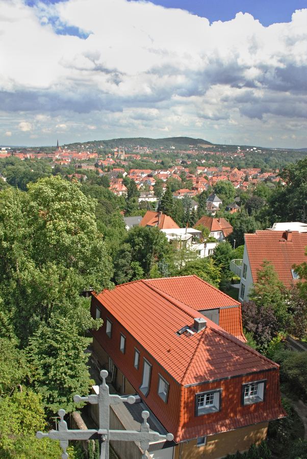 Luftbild eines Hauses mit rotem Ziegeldach über den Dächern der Stadt