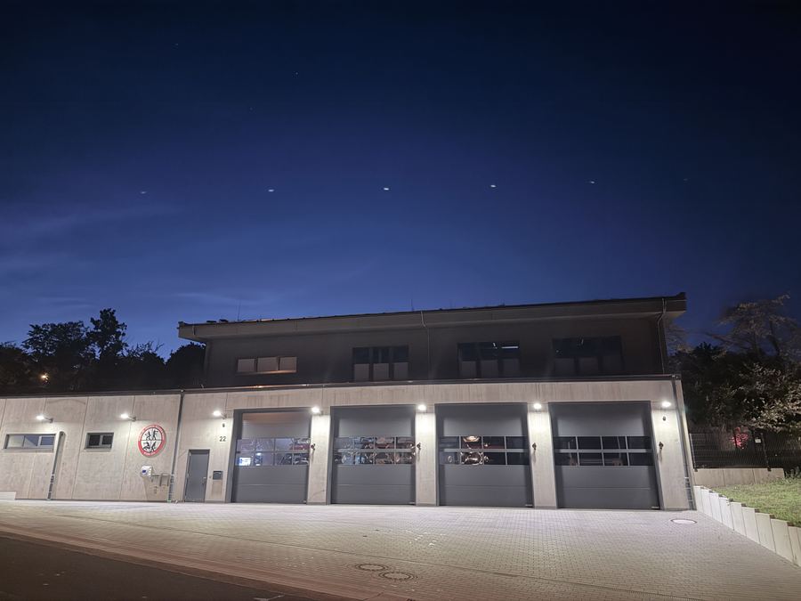 Feuerwehrhaus bei Nacht mit beleuchteten Toren
