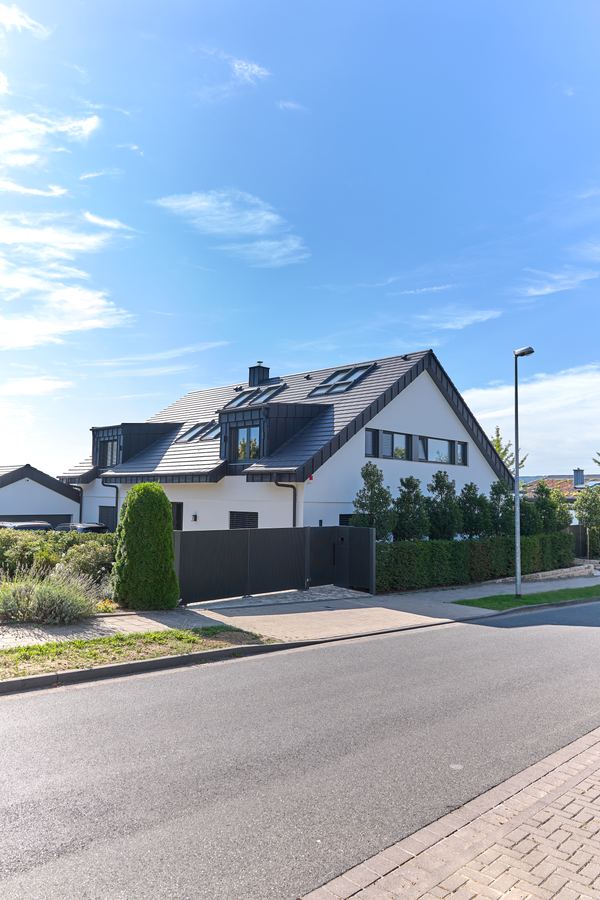 Einfamilienhaus mit Gauben und Vorgarten an einer ruhigen Straße