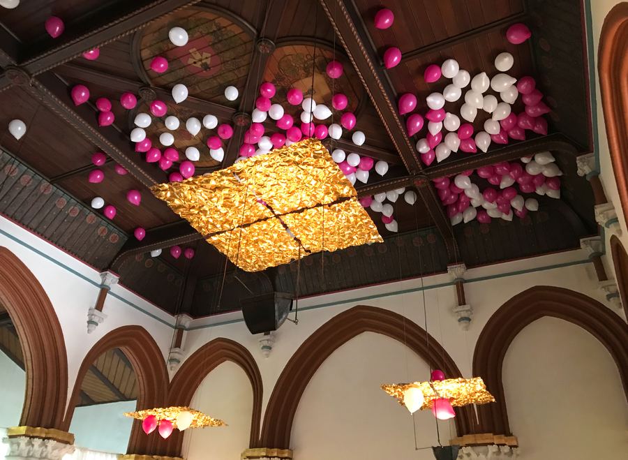 Historischer Saal mit Kreuzgewölbe und farbiger Ballondekoration an der Decke